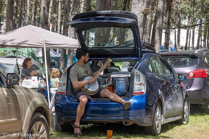 man camping in car blue ox music festival